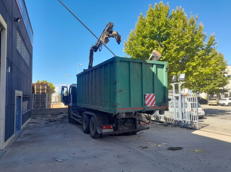 Camión cargando escombros tras vaciado de nave industrial